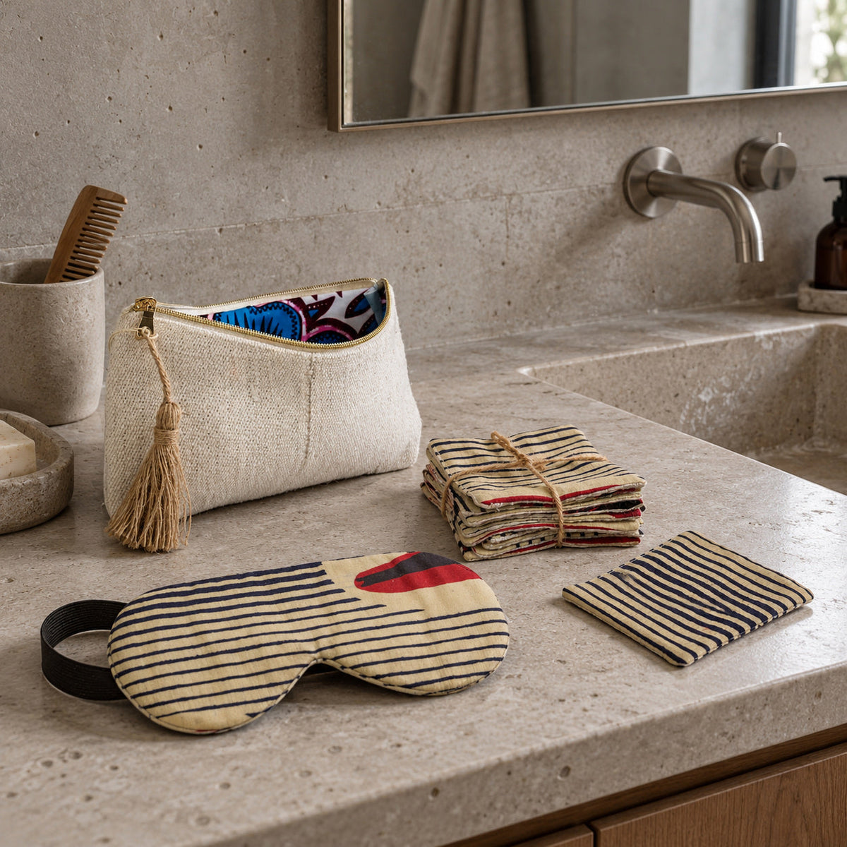 Trousse ROHO-KIDO crème, carrés démaquillants SAFI-MTOTO et masque de nuit DARE sur un plan de toilette en pierre claire.
