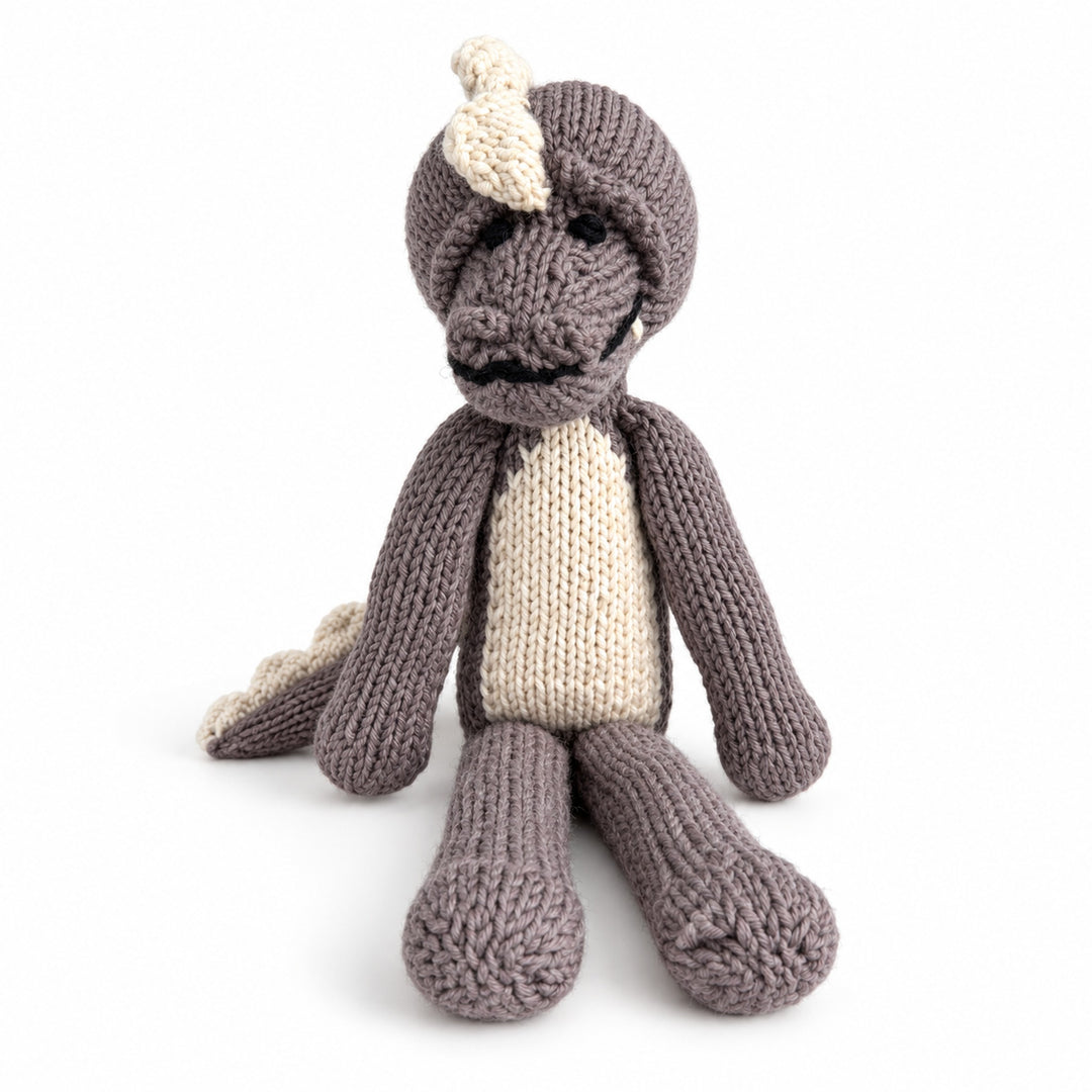 Doudou crocodile MAXIME taupe en coton tricoté, assis de face sur fond blanc.
