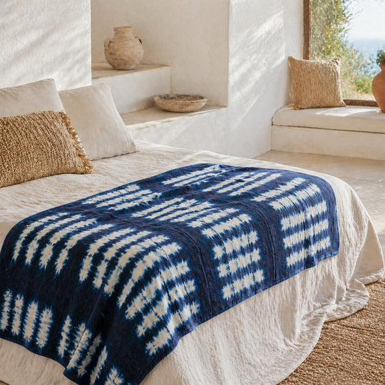 le plaid ZANA-BAHARI en bogolan et double gaze de coton dans une chambre à l'esprit méiterranéen