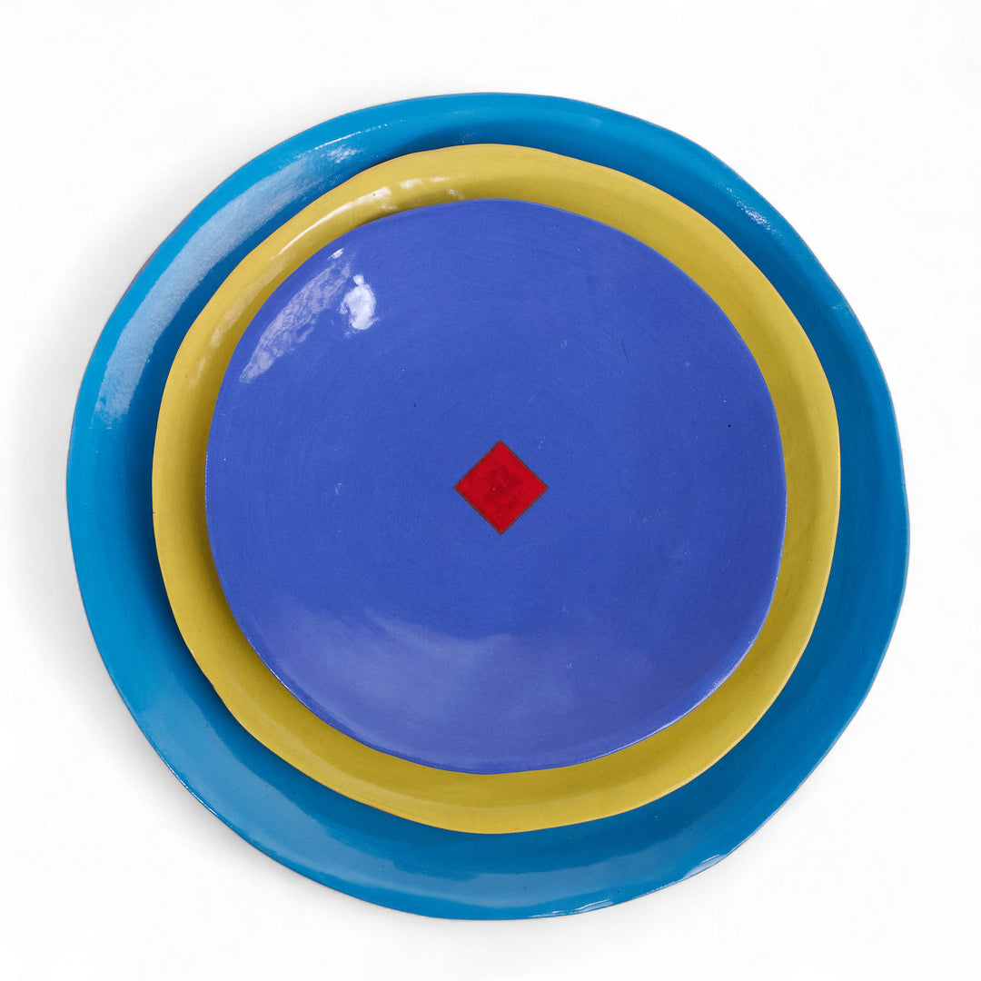 Coffret de 3 assiettes en céramique Color Me Bright par l'artiste sud-africaine Clementina Van Der Waltz. 
Détail des assiettes ( coloris et diamètre)
- Assiette de présentation : Bleu - 28 cm 
- Grande Assiette : Citron - 23 cm 
- Assiette à Dessert : Cobalt - 18 cm