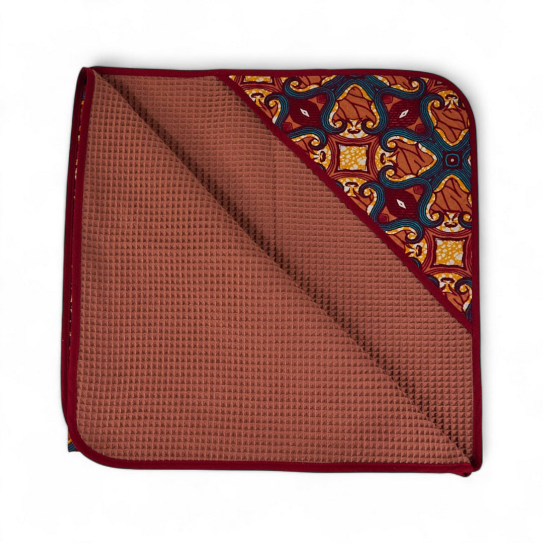 Cape de bain bébé MALAIKA en wax de coton doublé de piqué de coton gaufré nid d'abeille bois de rose. 88 x 88 cm.