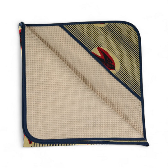 Cape de bain bébé MALAIKA en wax de coton doublé de piqué de coton gaufré nid d'abeille écru. 88 x 88 cm.