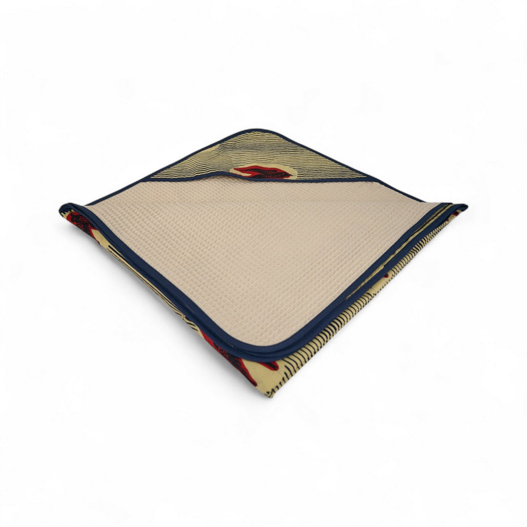 Cape de bain bébé MALAIKA en wax de coton doublé de piqué de coton gaufré nid d'abeille écru. 88 x 88 cm.