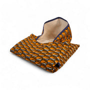 Poncho de bain enfant SIMBA-CAURI plié, face wax orange à motifs cauris et doublure éponge gaufrée écrue.
