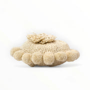 Coussin rond à pompons écru BONBONSI en pure laine mérinos, 30 cm de diamètre. Tricoté main par Kenana Knitters pour Studio Matongé. Disponible en 2 tailles (30 cm et 50cm de diamètre) et 3 couleurs (blanc écru, beige et marron foncé). Insert fourni
