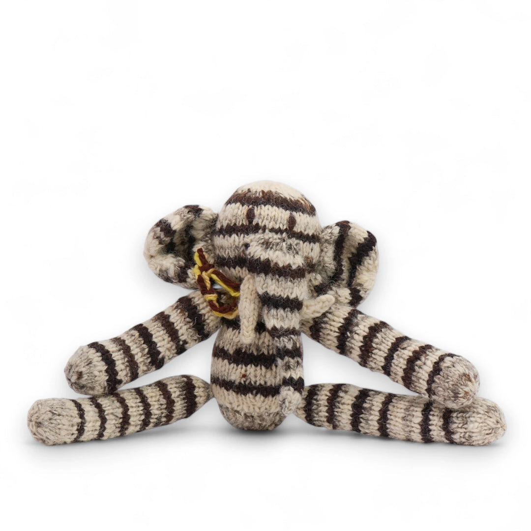 Doudou éléphant gris à longue pattes. Modèle HARRY en pure laine mérinos. Tricotté main par les femmes artisans de la coopérative Kenana Knitters au Kenya. En laine naturelle, non teintée. Ici en version rayé.