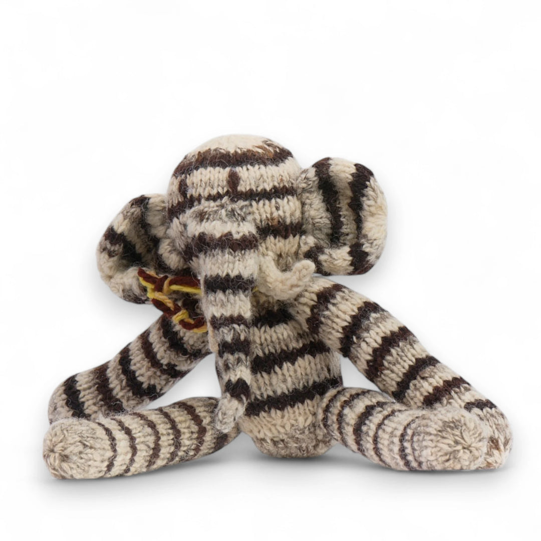 Doudou éléphant gris à longue pattes. Modèle HARRY en pure laine mérinos. Tricotté main par les femmes artisans de la coopérative Kenana Knitters au Kenya. En laine naturelle, non teintée. Ici en version rayé.
