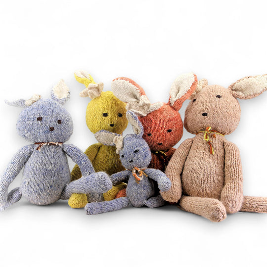 Famille de doudous SIMONE, notre peluche lapin ici en  jaune, bleu, corail et beige en tailles S et L, en laine bio faite main éco-responsable. Le doudou lapin SIMONE est disponible en 2 tailles et plusieurs couleurs chez Studio Matongé.