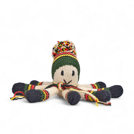 Doudou pieuvre NAIA en laine tricotée main, bonnet à pompon multicolore et tentacules rayées kaki, noir, jaune et rouge, vue de face.