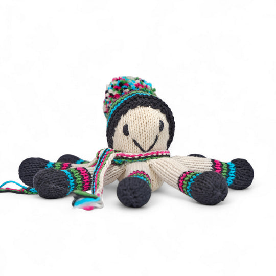 Doudou pieuvre NAIA en laine tricotée main, bonnet à pompon multicolore et tentacules rayées turquoise, turquoise, vert noir et fuschia, vue de face sur fond blanc.