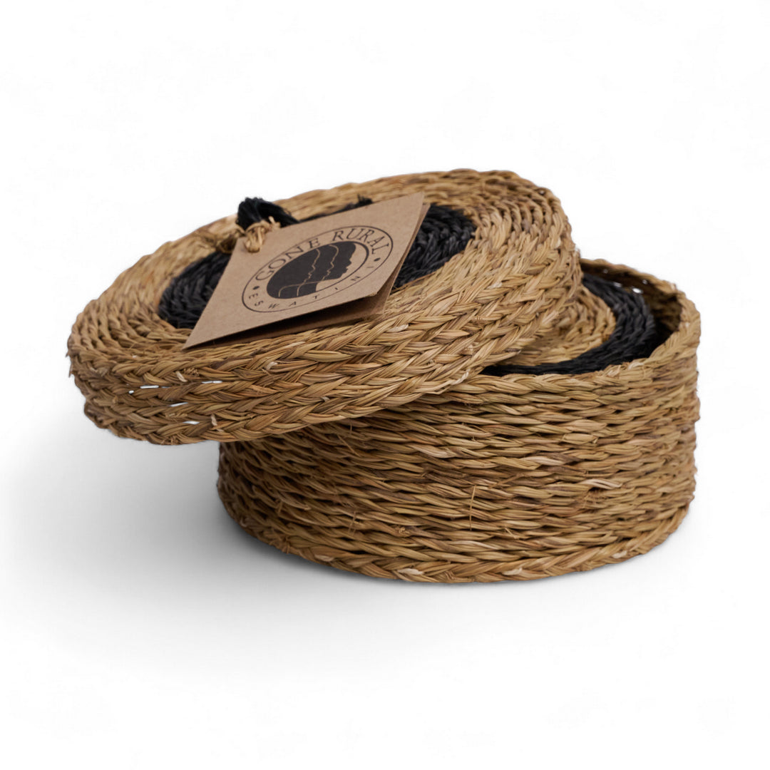 Coffret de 6 sous-verres en raphia. tressé main en Eswatini par la copérative Gone Rural. ici en noir et smoke. disponible en plusieurs teintes.