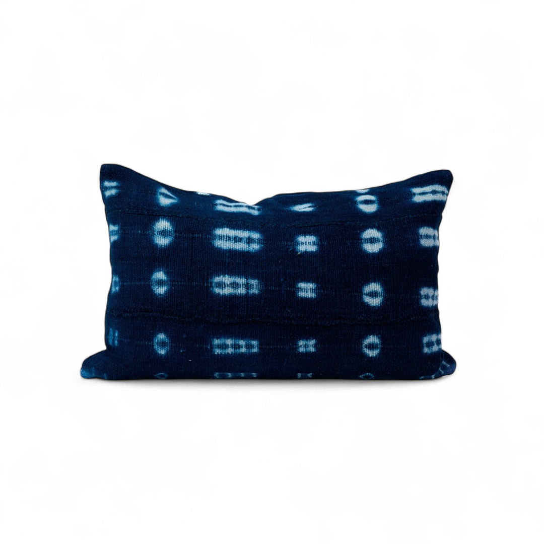 Housse de coussin ethnique en bogolan indigo BAHARINI. Entièrement réalisée à la main. Housse de coussin zippée rectangle 30 x 50 cm. 100% coton bio. Tissage et teinture artisanaux réalisés au Mali. Confection réalisée en Belgique. 