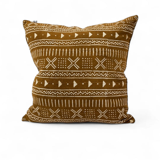 Housse de coussin ethnique KEUR 60 x 60cm par Studio Matonge. Confectionné en Belgique à partir de tissu africain bogolan ocre à motifs blancs, tissés et teints à la main par des artisans de la région de Ségou.