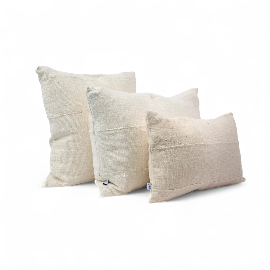 Housses de coussin crèmes en bogolan de coton bio par Studio Matongé. Pièces uniques tissées, filées et confectionnées à la main. Formats rectangle 30 x 50 cm & 40 x 60 cm. Format carré 50 x 50 cm. #blanc