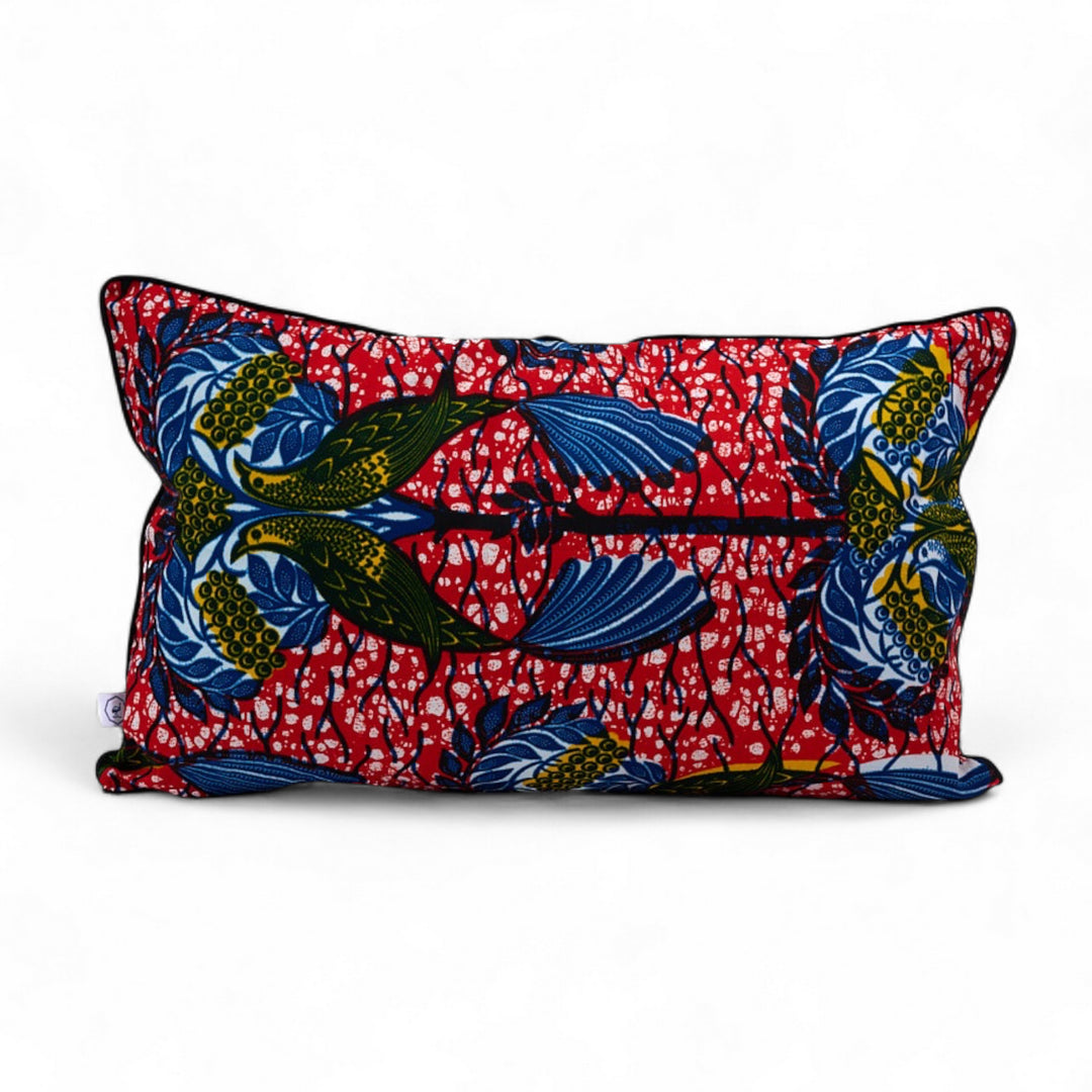 Housse de coussin FANA-NDEGE par Studio Matongé. En wax rouge orné d'oiseaux jaunes et bleus. 30 x 50 cm. 100% coton. Finition passepoil noir. Housse zippée.  