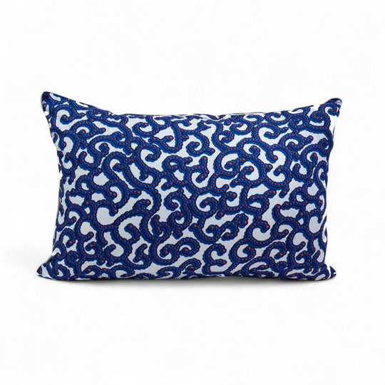 OSUN-KOORAAL, housse de coussin ethnique 
wax blanc, bleu, corail réhaussé d'un passepoil argenté  40 x 60 cm Studio Matongé