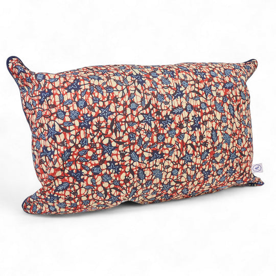Housse de coussin rectangulaire en wax OSUN-DUMA, 30 x 50 cm. Le motif fleur de piment décliné en bordeaux et bleu marine, apporte une touche ethnique sobre à votre intérieur.