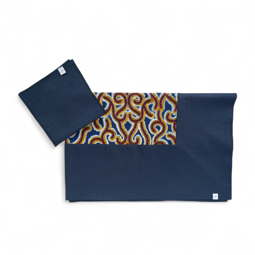 Nappe GIDA-LADHA en lin et wax bleu marine. Format rectangle 158 x 250 cm. 
Ici avec les serviettes en lin SAVUTI 45 x 45 cm coordonnées. 
Confectionné artisanalement par des ateliers protégés en Belgique.