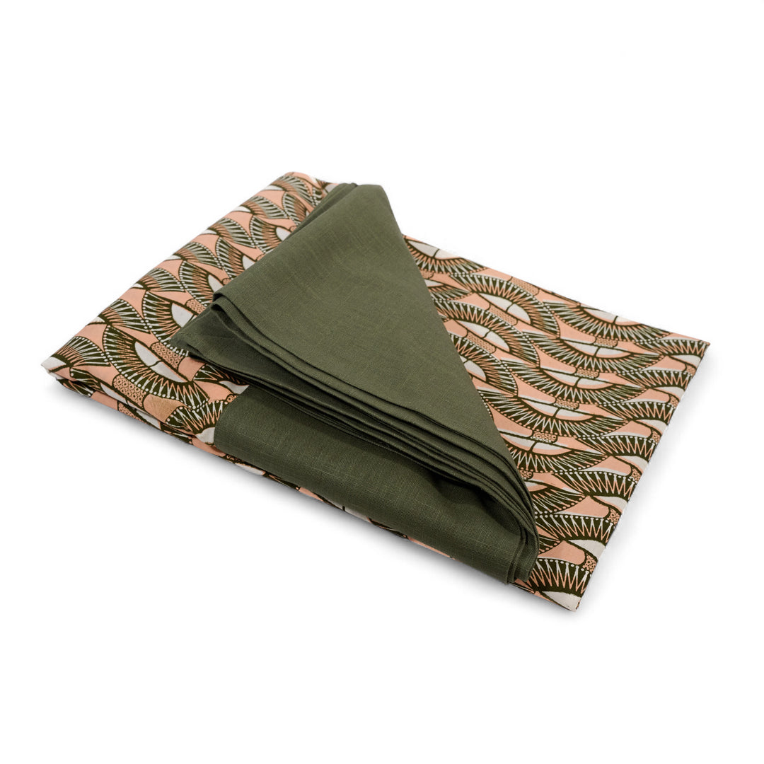 Nappe GIDA_SENI pliée sur fond blanc. Bord en lin kaki et centre en wax kaki,, rose et blanc.
Ici rectangulaire : 158 x 250 cm. Existe aussi en format carré 130 x 130 cm.
A assortir avec nos serviettes AYO ou SAVUTI.