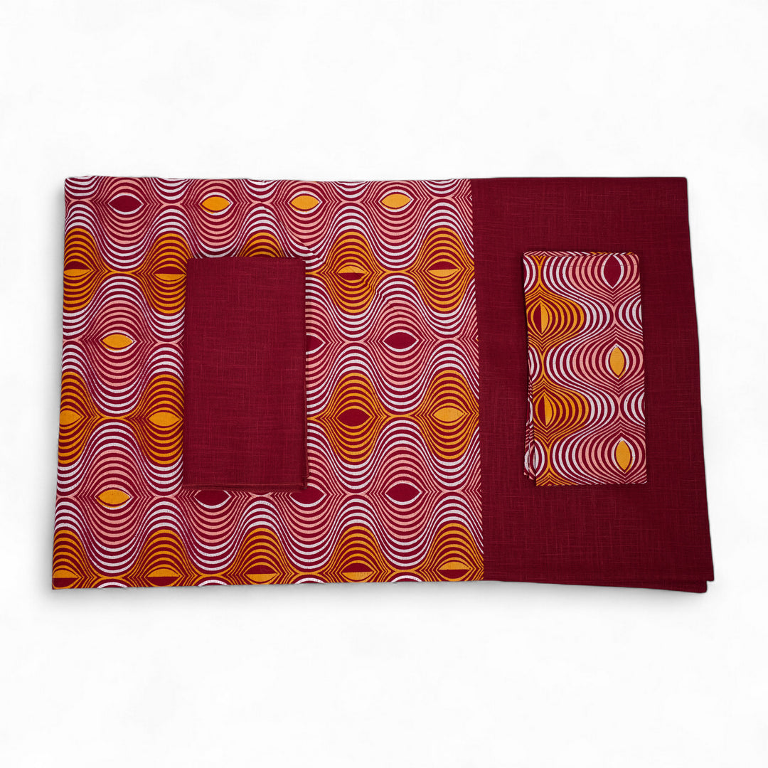 Nappe GIDA_ZUBA pliée sur fond blanc. Bord en lin bordeaux et centre en wax bordeaux, abricot, rose dragée et blanc.
Existe en formats rectangulaire : 158 x 250 cm ou carré 130 x 130 cm.
Ici avec nos serviettes AYO ou SAVUTI coordonnées.