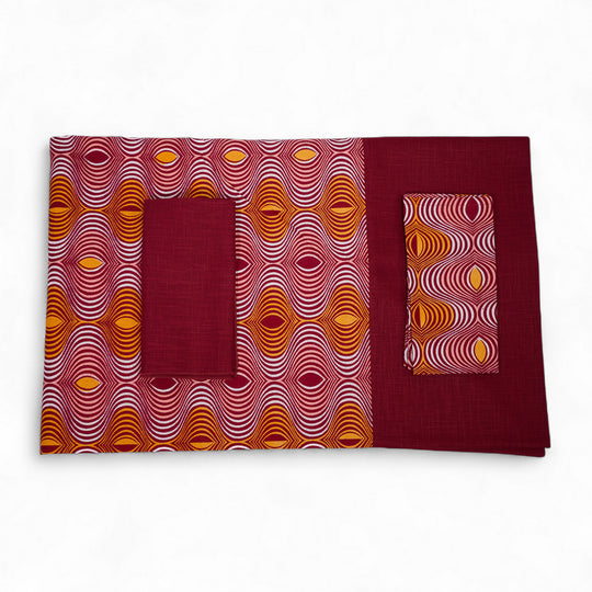Nappe GIDA_ZUBA pliée sur fond blanc. Bord en lin bordeaux et centre en wax bordeaux, abricot, rose dragée et blanc.
Existe en formats rectangulaire : 158 x 250 cm ou carré 130 x 130 cm.
Ici avec nos serviettes AYO ou SAVUTI coordonnées.