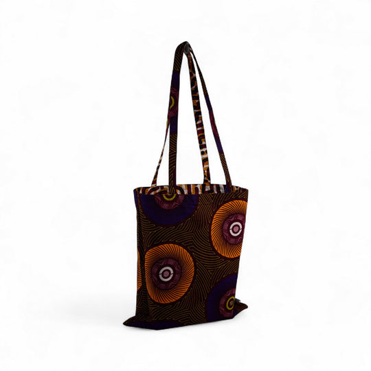 Tote bag réversible ILANGA en wax. Confectionné à la main en Belgique dans des ateliers de réinsertions professionnelle. Pur coton. Ici en combinaison graphique aux dominantes marron, jaune et bordeaux.
