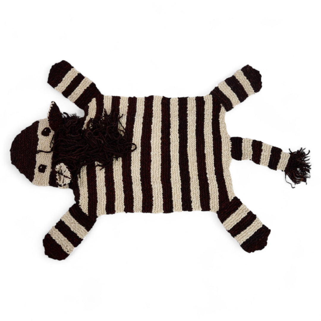 ZOE, tapis zèbre fait main en pure laine mérinos. Parfait en tapis ou descente de lit dans une chambre d'enfant ou une salle de jeu. Sa laine est si douce que vous pouvez aussi l'utiliser en petite couverture pour les petits. C'est vous qui décidez. 