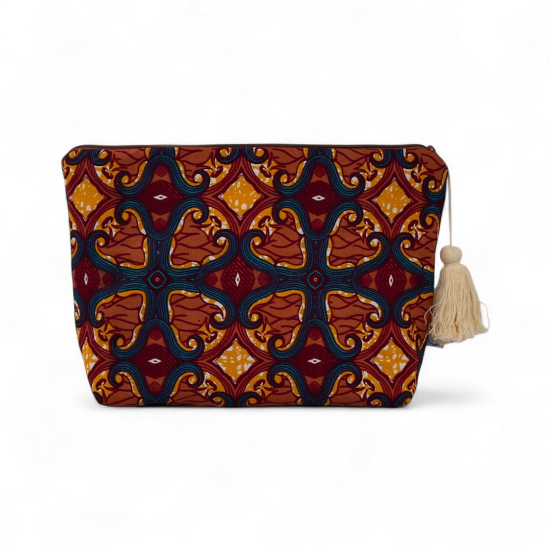 Trousse de toilette MALAIKA en wax de coton multicolore, doublé de piqué de coton gaufré nid d'abeille bois de rose. La trousse MALAIKA de Studio Matongé est agrémentée d'un joli pompon de coton. Dimensions : 38 x 29 cm