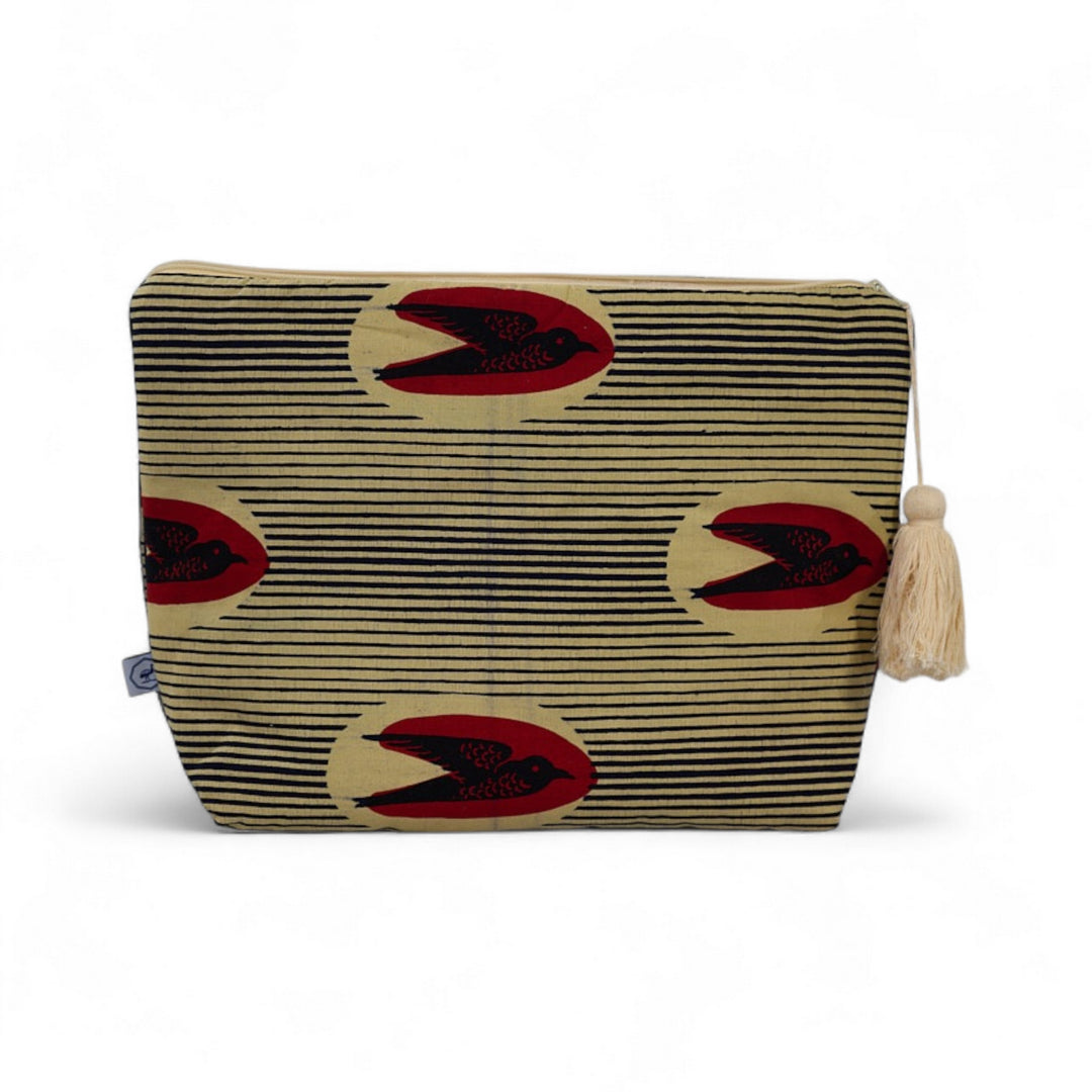 Trousse de toilette MTOTO en wax de coton hirondelle doublé de piqué de coton gaufré nid d'abeille écru, agrémentée d'un joli pompon de coton. Dimensions : 38 x 29 cm