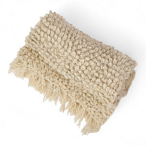Plaid TANGGOOR en laine ecrue plie, grosses boucles en relief et franges, tricote main au Kenya