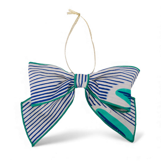 Nœud décoratif de Noël ZAWADI en wax MTOTO blanc à rayures bleues et motifs verts, fabriqué à la main à partir de chutes de tissu, Studio Matongé.