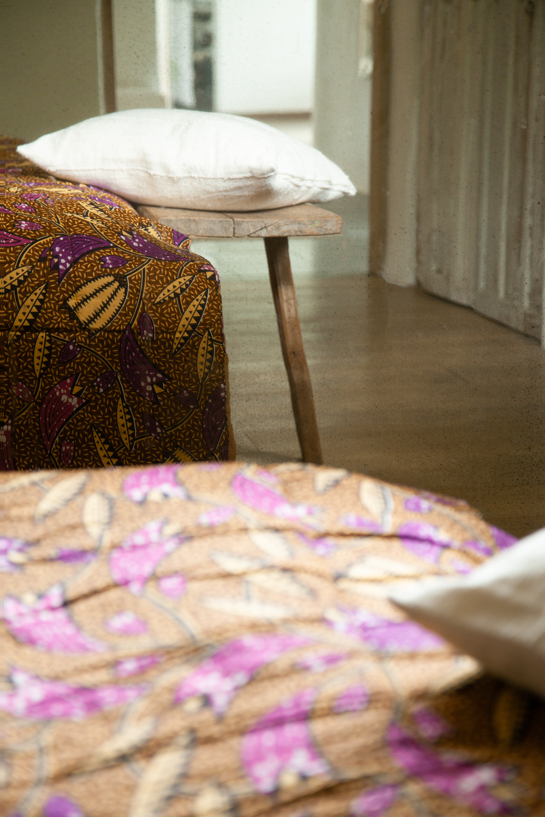 Couvre-pieds FUNTENI en wax de coton version caramel, accompagné de la housse de coussin en bogolan de coton blanc MSINGI carré 50 x 50 cm. #blanc