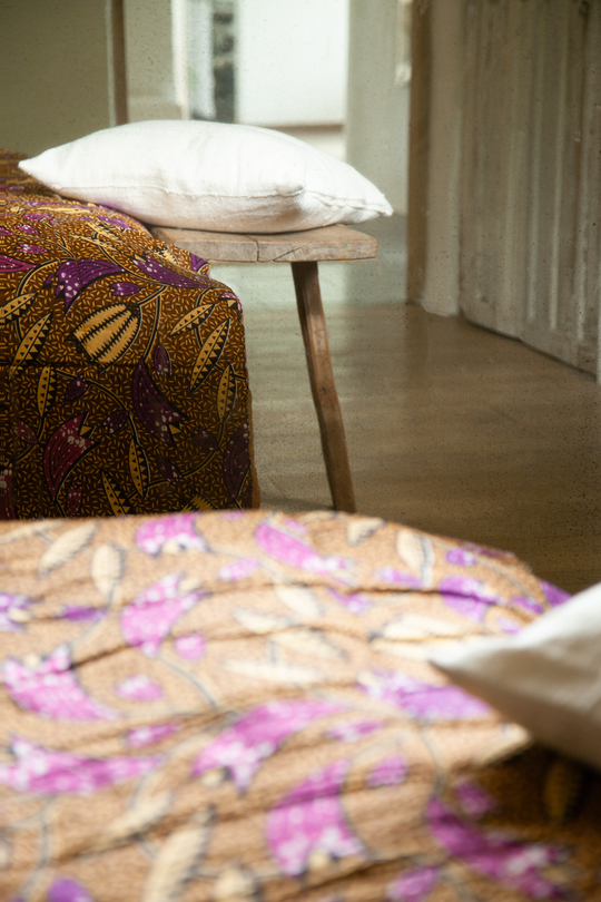 Couvre-pieds FUNTENI en wax de coton version caramel, accompagné de la housse de coussin en bogolan de coton blanc MSINGI carré 50 x 50 cm. #blanc