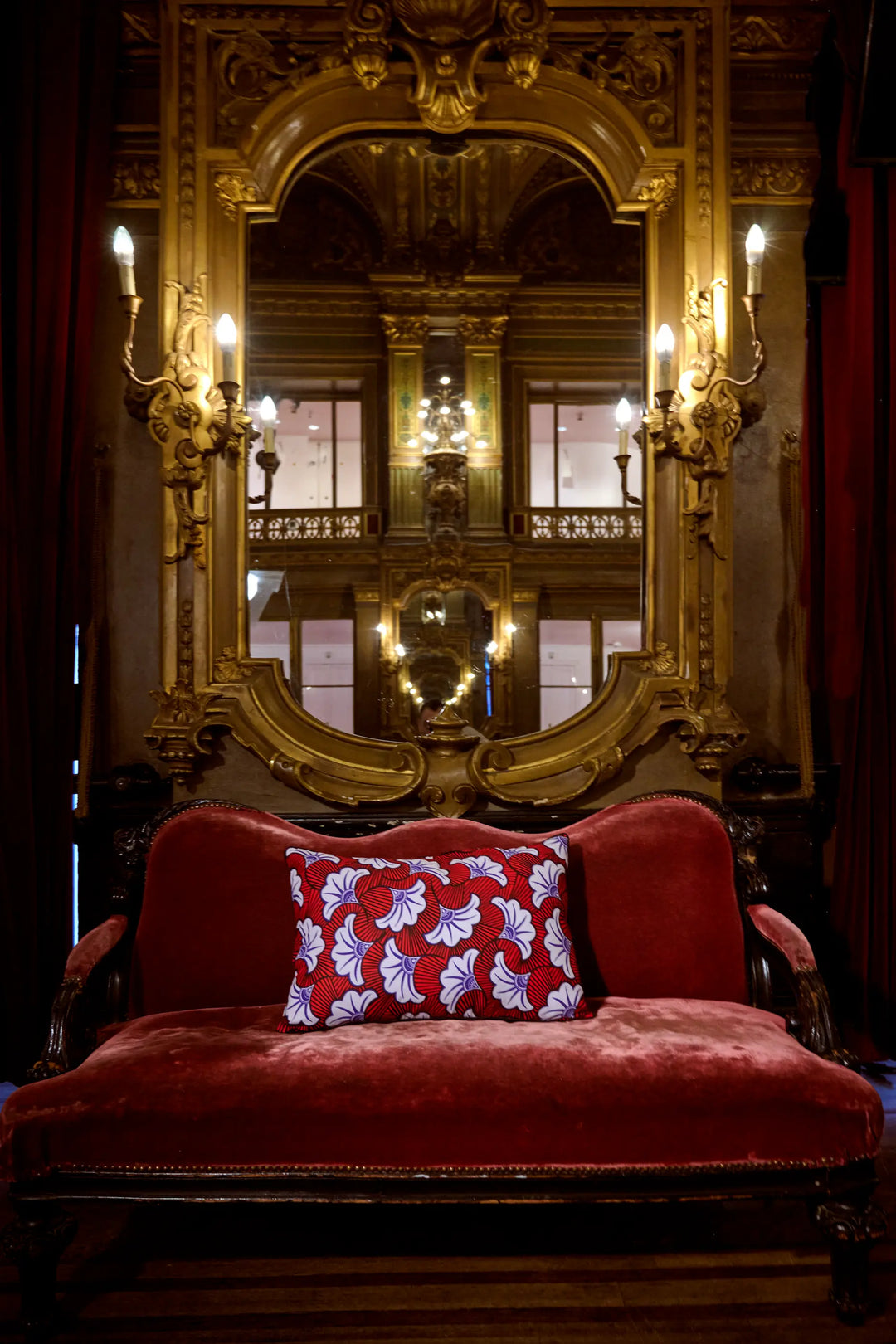 Dans les magnifiques décors du grand foyer de l'Opéra de la Monnaie de Bruxelles, housse de coussin en wax - UA rouge 40 x 60 cm - Studio Matongé. Fait main en Belgique. 