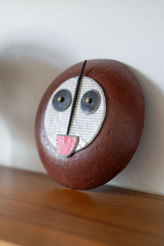 Masque africain stylisé design réalisé en papier mâché recyclé - TUTU - Quazidesign - Studio Matongé 
pose sur une étagère de bibliothèque fifties