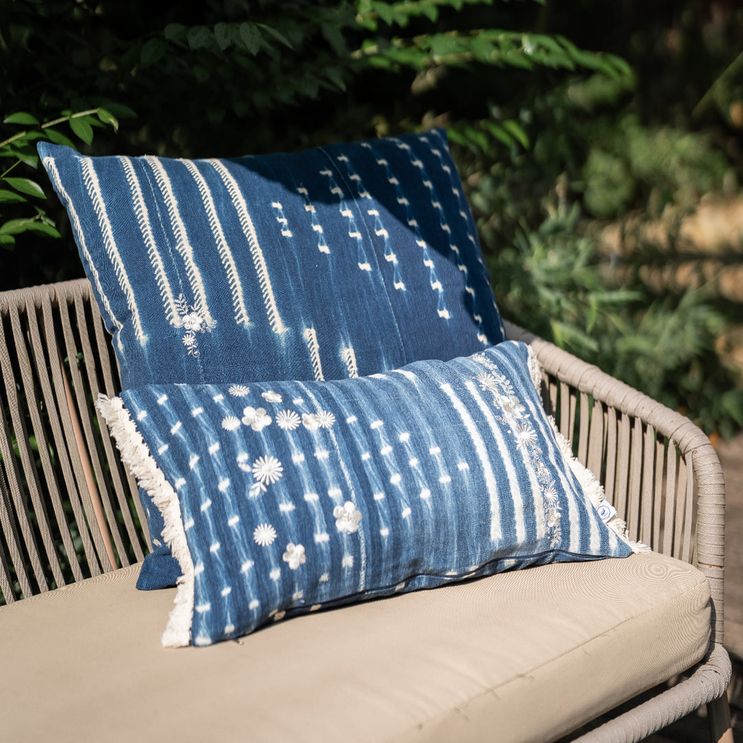 Housse de coussin à franges ZABUNI-ZARI, en indigo vintage upcyclé, rehaussé de broderies fleuries blanc ivoire. 30 x 50 cm. 
Ici en mix and match avec une housse de coussin en indigo vintage BUUM-ZARI, également upcyclée et brodée. 
Pièces uniques : l'emplacement et la quantité de broderies ainsi que l'emplacement des motifs dans la trame diffère sur chaque pièce. 