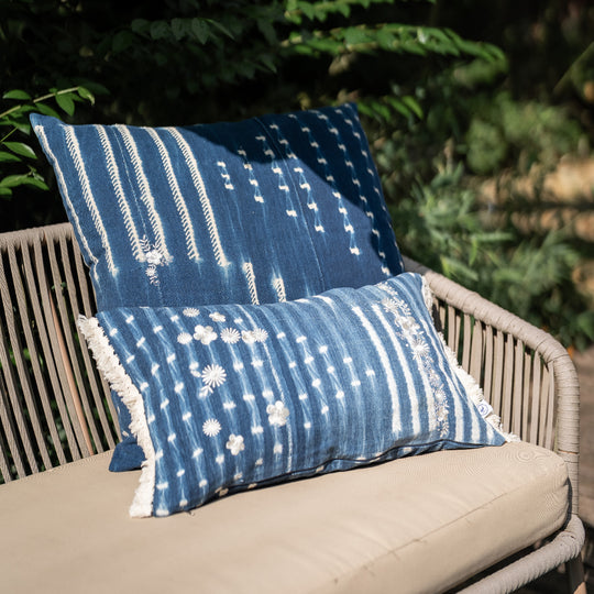 Housse de coussin à franges ZABUNI-ZARI, en indigo vintage upcyclé, rehaussé de broderies fleuries blanc ivoire. 30 x 50 cm. 
Ici en mix and match avec une housse de coussin en indigo vintage BUUM-ZARI, également upcyclée et brodée. 
Pièces uniques : l'emplacement et la quantité de broderies ainsi que l'emplacement des motifs dans la trame diffère sur chaque pièce. 