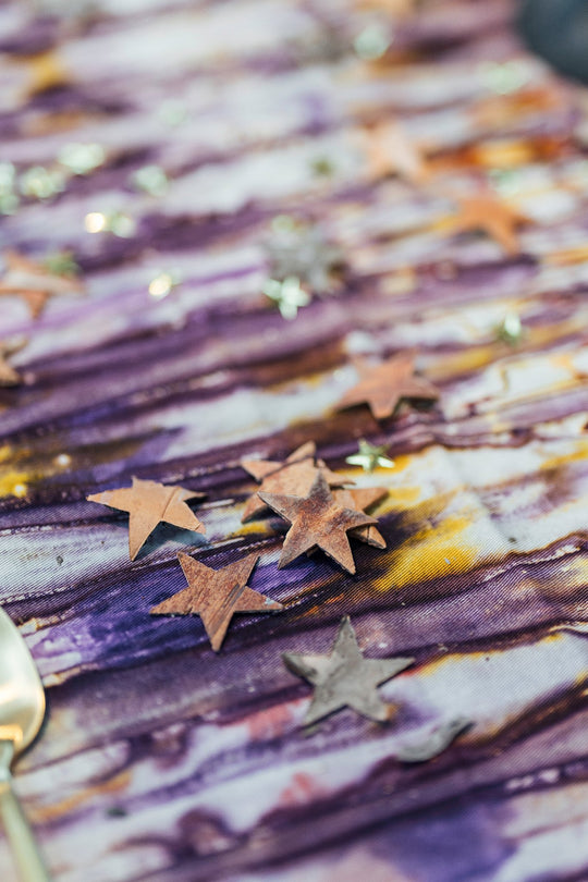 Nappe de fêtes - détail tissu kokodunda violet et jaune – teinture traditionnelle – Studio Matongé, parsemé d'étoiles en écorce.