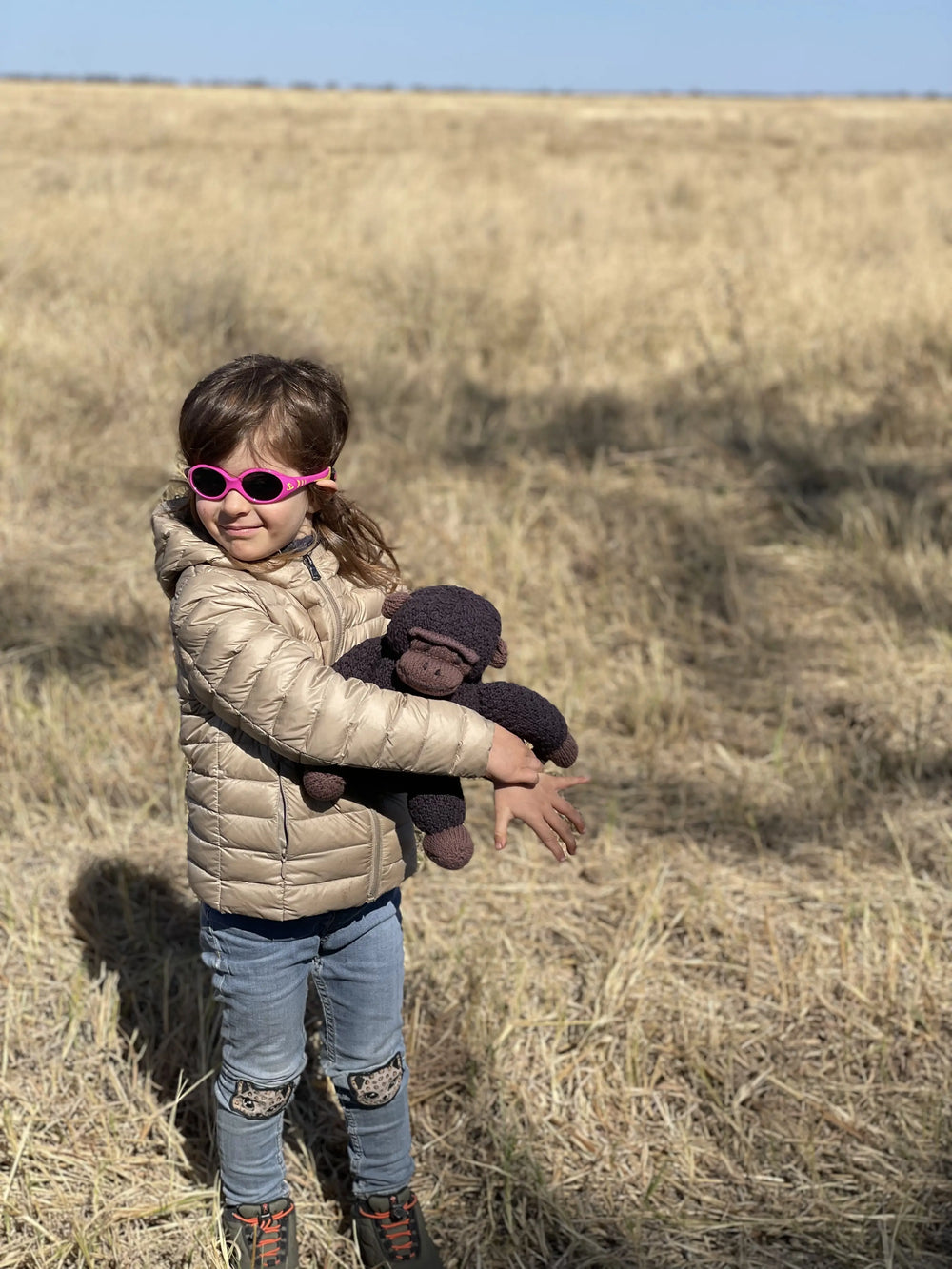 Avec ROGER, peluche gorille faite main, en coton bio certifié GOTS dans les plaines herbeuses du parc de Savuti - Studio Matongé