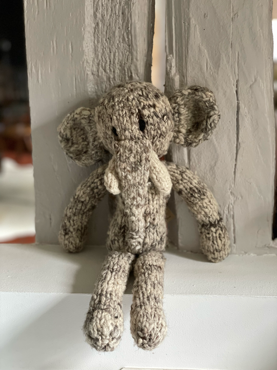 Doudou éléphant gris à longue pattes. Modèle HARRY en pure laine mérinos. Tricotté main par les femmes artisans de la coopérative Kenana Knitters au Kenya. En laine naturelle, non teintée. Ici en version gris chiné.