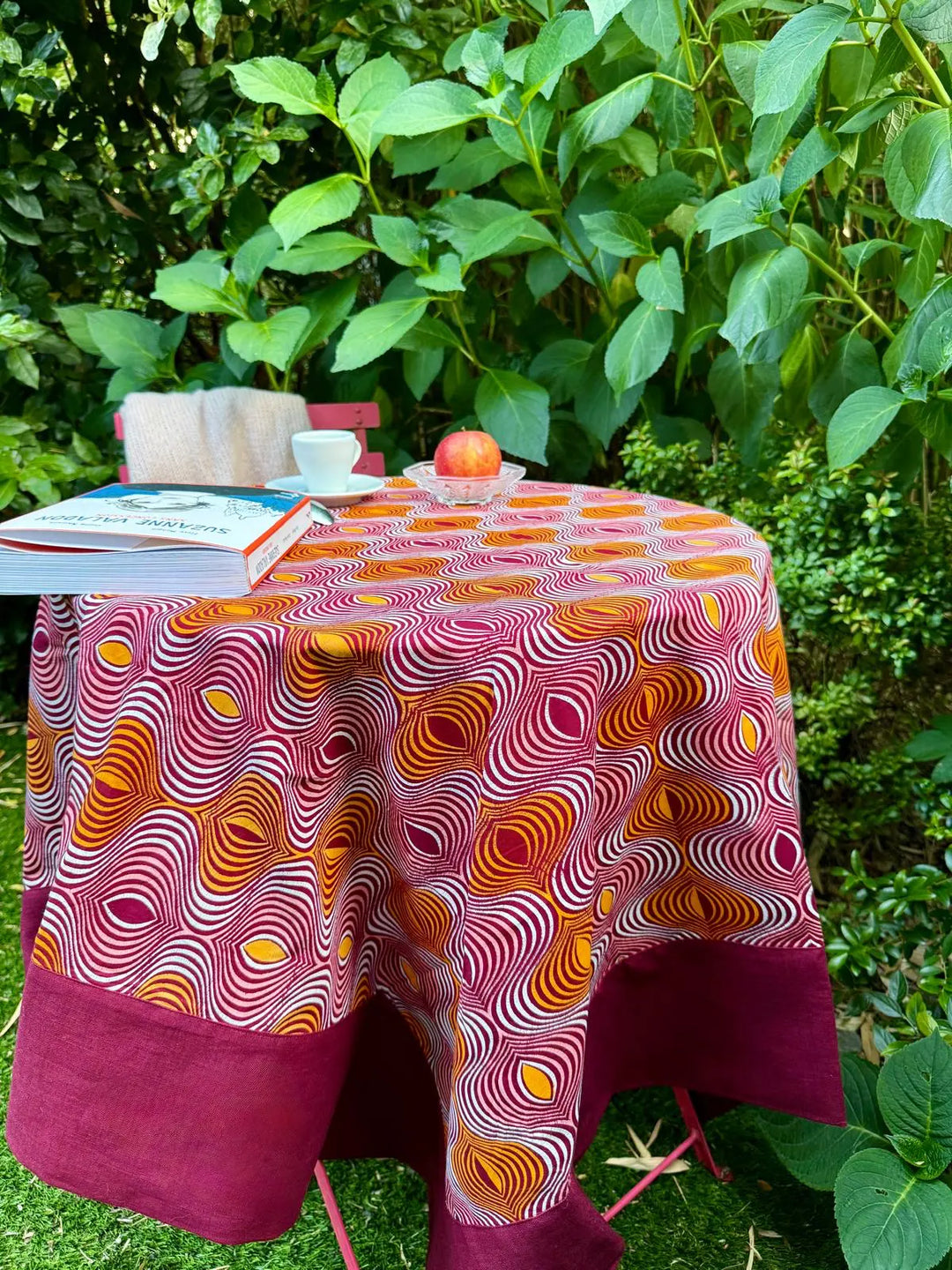 Nappe GIDA-ZUBA en format 130 x 130 cm sur une table ronde de jardin.