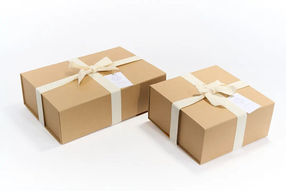 Box cadeau de naissance pour nouveau-né proposés dans une élégante boite en kraft à fermeture aimantée réutilisable. 