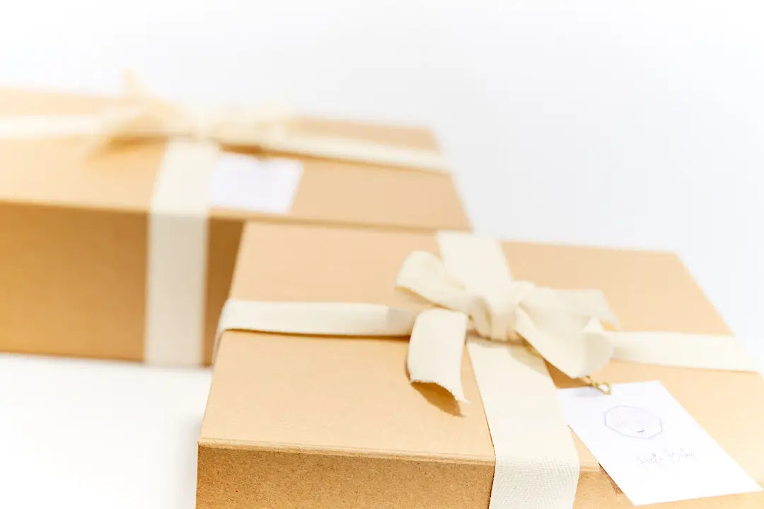 Box cadeau de naissance pour nouveau-né proposés dans une élégante boite en kraft à fermeture aimantée réutilisable. 
