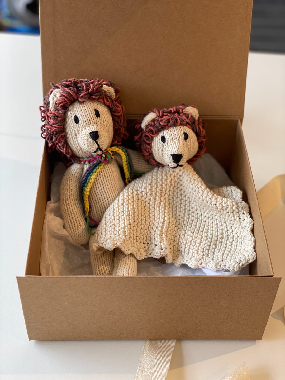 Box cadeau de naissance lions pour nouveau-né. 
Notre box contient : 
- pour bébé, 1 doudou plat HUGO & 1 doudou longue pattes LEONARD
- pour les heureux parents, une carte de félicitation incluant une remise valable 1 an à l'achat d'un doudou de notre collection
- une élégante boite en kraft à fermeture aimantée réutilisable, idéale pour ranger les affaires de bébé