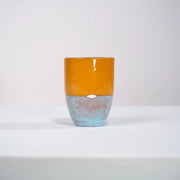 Mug MMOHO en céramique par la céramiste Sud-Africaine Clementina van der Walt pour Done d'Africa x Studio Matongé.
8 cm de diamètre et 11,5 cm de hauteur, parfait pour vos grands cafés, thés et infusions. 
Ici en combinaison Abricot & Bleu Dragée