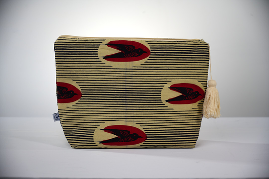 Trousse de toilette MTOTO en wax de coton hirondelle doublé de piqué de coton gaufré nid d'abeille écru, agrémentée d'un joli pompon de coton. Dimensions : 38 x 29 cm