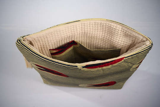 Trousse de toilette MTOTO en wax de coton hirondelle doublé de piqué de coton gaufré nid d'abeille écru, agrémentée d'un joli pompon de coton. Dimensions : 38 x 29 cm