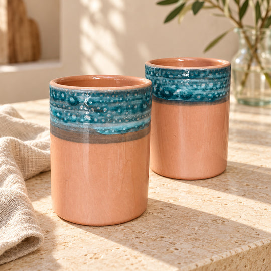Paire de mugs en céramique sans anse, décor Terracotta - frange turquoise, sur une table en pierre claire