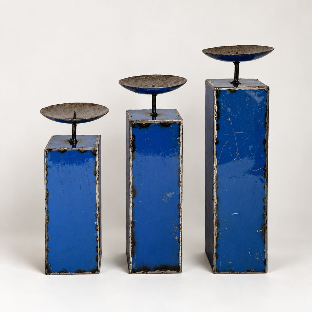 Trio de grands bougeoirs NURU en métal recyclé bleu, présentés par hauteur croissante sur fond clair.