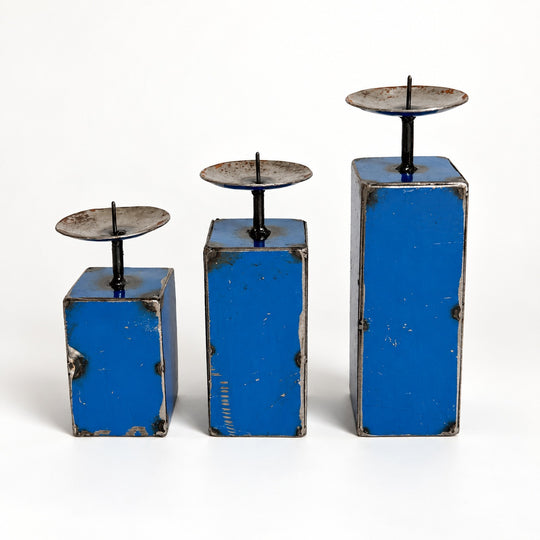 Trio de petits bougeoirs NURU en métal recyclé bleu, présentés par hauteur croissante sur fond clair.